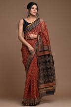 Woman wearing a traditional saree with a brown background