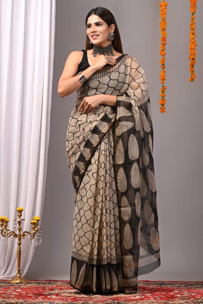 Woman wearing a patterned saree with a decorative background